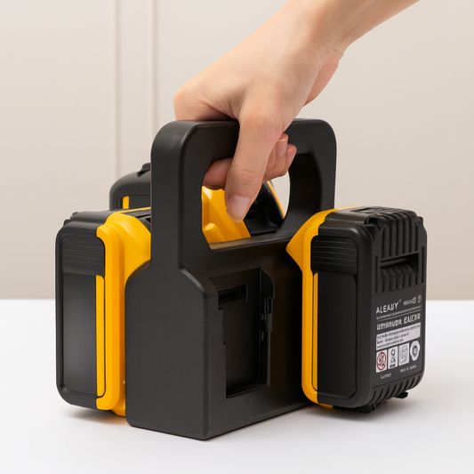 Hand holding a black and yellow tool carrier with batteries on a white surface
